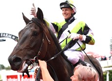 Danny Peisley celebartes aboard Obstructionist in the winner's enclosure after scoring an untroubled win, leading all of the way