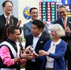 Mrs Sheila Ip (right), wife of Dr Simon S O Ip, Chairman of the HKJC, presents a souvenir to the winning jockey Neil Callan. 