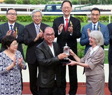 Mrs Sheila Ip (front row, first from right), wife of Dr Simon S O Ip, Chairman of the Hong Kong Jockey Club, presents the Kwangtung Handicap Cup to the winning Owner Peter Law Kin Sang (front row, middle) ...