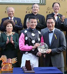 Mr. Michael TH Lee, Steward of the Hong Kong Jockey Club, presents the Trophy and silver dish to jockey Derek Leung

Photos: Courtesy Hong Kong Jockey Club