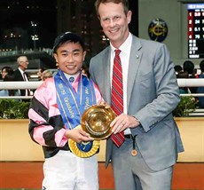 Andrew Harding, Executive Director of Racing at the Hong Kong Jockey Club, presents a silver-gilt dish to Dylan Mo at the graduation ceremony.