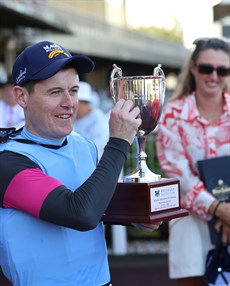 Luke Dempsey with the spoils of victory after his win in the Group 3 Vo Rogue aboard Give Me Space 